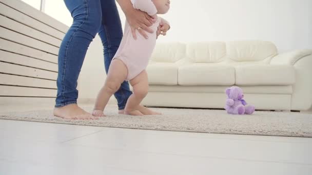 Bebê dando os primeiros passos com as mães ajuda em casa — Vídeo de Stock