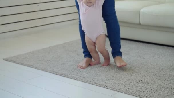 Baby tar första steg med mödrar hjälp hemma — Stockvideo