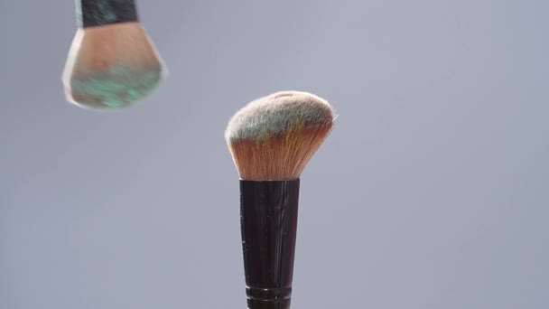 Make-up brush with green powder splashes explosion on gray background on slow motion — Stock Video