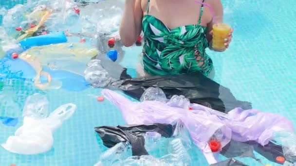 Konzept der Umweltverschmutzung des Planeten. Junge geschockte Frau schwimmt im Müll — Stockvideo