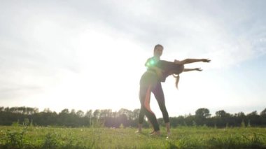 Fitness, spor, dostluk ve yaşam tarzı konsepti - İki genç kadın gün batımında açık havada uzanan eğitim