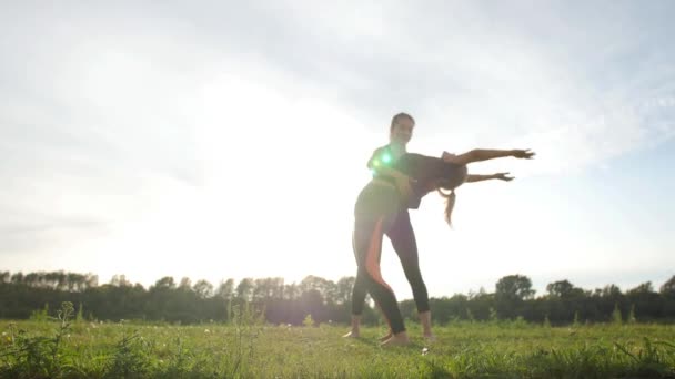 Fitness, deporte, amistad y estilo de vida - Dos jóvenes están entrenando estirándose al aire libre al atardecer — Vídeo de stock