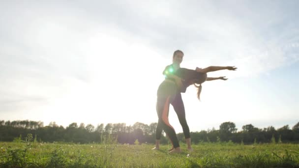 Fitness, sport, friendship and lifestyle concept - Two young women are training stretching outdoors at sunset — Stock Video