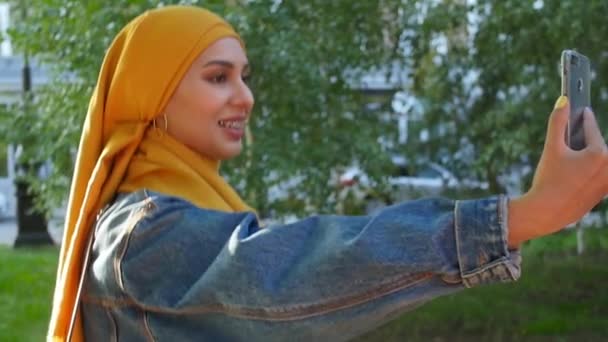Joven feliz hermosa mujer musulmana tomando selfie en la calle — Vídeo de stock