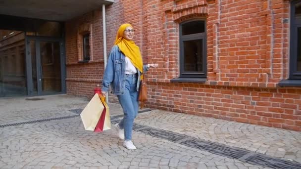 Jolie jeune femme musulmane avec tenue sacs à provisions après le shopping — Video