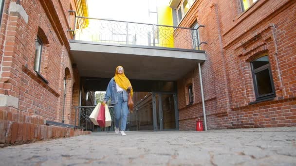 Alışveriş ten sonra alışveriş poşetleri tutan Pretty genç müslüman kadın — Stok video