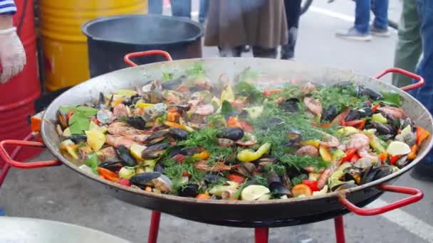 Nemzeti és utcai élelmiszer koncepció. Spanyol élelmiszer Seafood paella a nagy serpenyőben — Stock videók