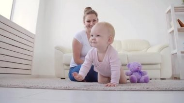 Çocukluk, bebeklik ve aile kavramı. Anne evde onu sevimli bebek ile oynuyor