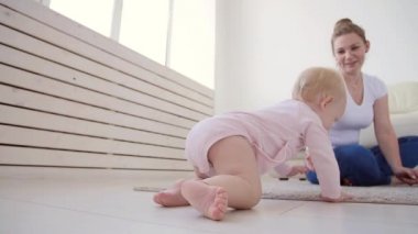 Çocukluk, bebeklik ve aile kavramı. Anne evde onu sevimli bebek ile oynuyor