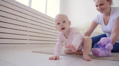 Çocukluk, bebeklik ve aile kavramı. Anne evde onu sevimli bebek ile oynuyor