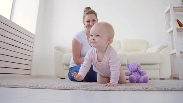 Barndom, barnsben och familjekoncept. Mamma leker med sin söta bebis hemma — Stockvideo