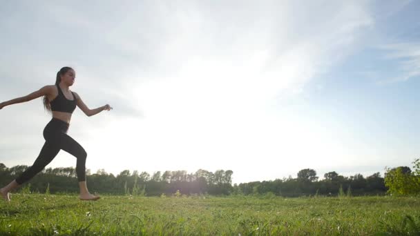 Концепция здоровья, растяжения и здорового образа жизни. Молодая спортсменка, сидящая на тренировке и растягивающаяся в парке на закате . — стоковое видео