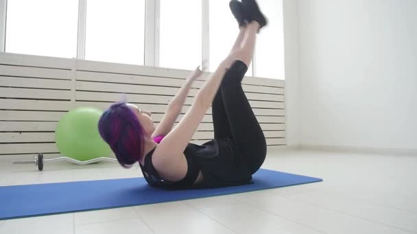 Sport und gesunder Lebensstil. junge Frau macht körperliche Übungen zu Hause oder im Fitnessstudio — Stockvideo