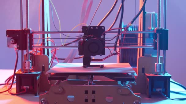 Impresión 3D o fabricación aditiva y concepto de automatización robótica. Trabajar impresora 3d en una luz de color — Vídeo de stock