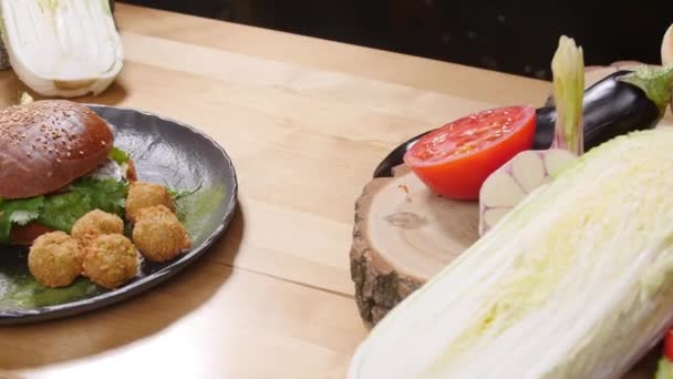 Tasty burger with falafel on a Rustic Wooden Surface — Stock Video