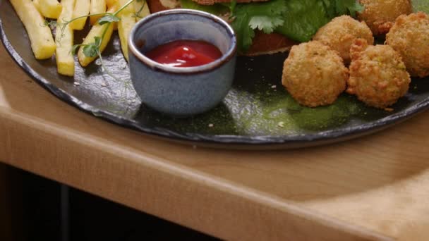 Hamburger savoureux avec falafel sur une surface en bois rustique — Video