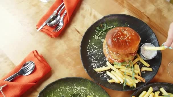 Lekkere hamburgers met frietjes op een geserveerd tafel. Uitzicht vanaf boven — Stockvideo