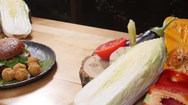 Hambúrguer saboroso com batatas fritas em uma superfície de madeira rústica — Vídeo de Stock