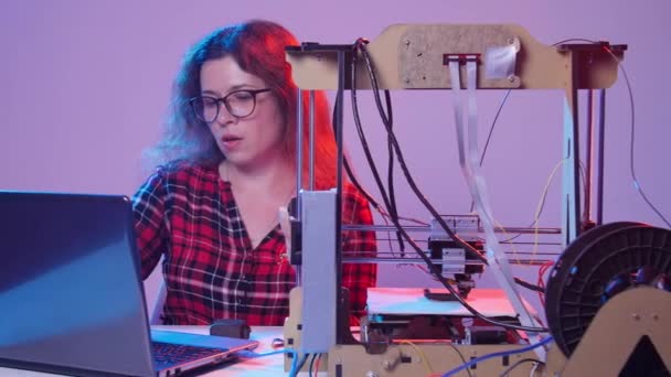 Konzept moderner Produktionstechnologien. junge Frau druckt ein Modell auf einem 3D-Drucker — Stockvideo