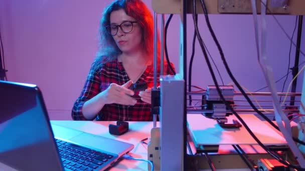 Concept van moderne productietechnologieën. Jonge vrouw drukt een model af op een 3D-printer — Stockvideo