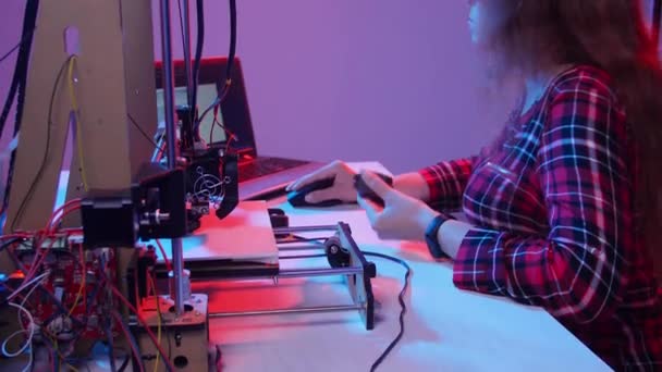 Concept of modern production technologies. Young woman prints a model on a 3D printer — Stock Video