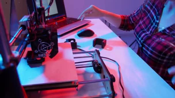 Concept van moderne productietechnologieën. Jonge vrouw drukt een model af op een 3D-printer — Stockvideo