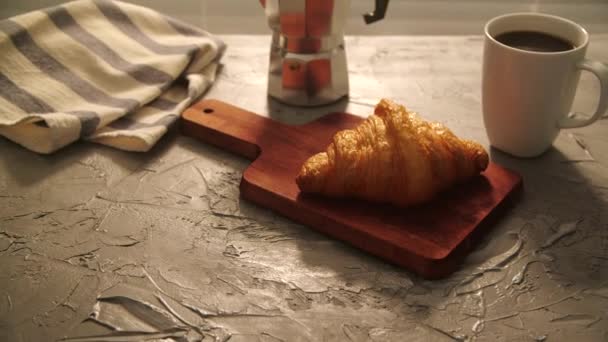 Concepto de comida y bebida. El desayuno de la mañana - el café y el croissant a la mesa — Vídeos de Stock