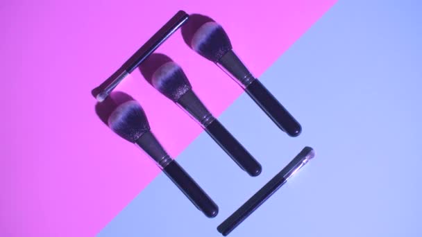 Conjunto de vista superior plana de cepillo de cosméticos femeninos profesionales para maquillaje sobre fondo rosa y azul, concepto de cosméticos, concepto de maquillaje — Vídeos de Stock