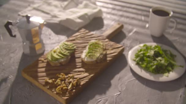 Concepto de desayuno saludable. Tostadas con crema de aguacate sobre tabla de madera — Vídeos de Stock