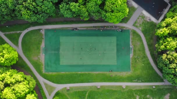 Aerial view of men playing football on a public city soccer field — Stock Video