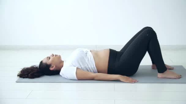 Concept de santé. Jeune femme enceinte fait de l'exercice de yoga dans la chambre blanche — Video