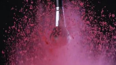 Güzellik konsepti. Siyah arkaplanda barut izleriyle makyaj fırçası