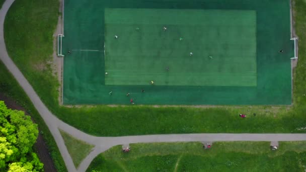 Аерофотозйомка чоловіків, які грають у футбол на футбольному полі громадського міста — стокове відео