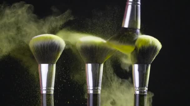 Il concetto di bellezza. Spazzola cosmetica con polvere cosmetica dorata diffusa su sfondo nero — Video Stock