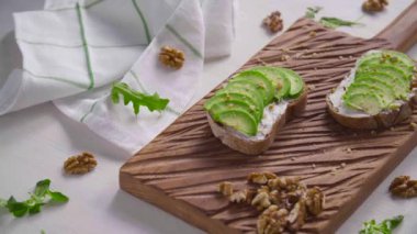 Sağlıklı beslenme konsepti. Beyaz tahta üzerinde avokado kremalı tost.