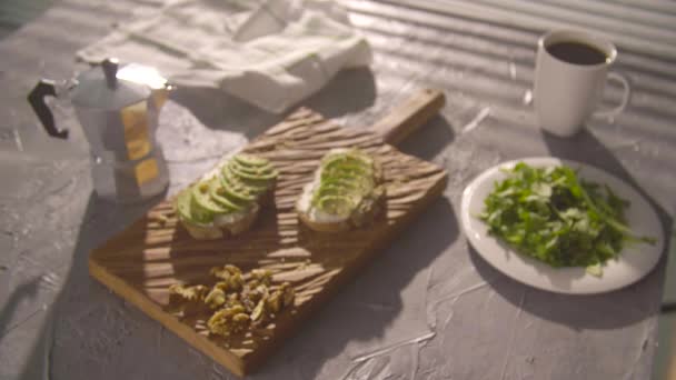 Concepto de desayuno saludable. Tostadas con crema de aguacate sobre tabla de madera — Vídeos de Stock