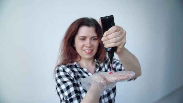 Beauty and hair care concept.. Happy young woman with a tube of hair dye — Stock Video