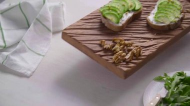 Sağlıklı beslenme konsepti. Beyaz tahta üzerinde avokado kremalı tost.