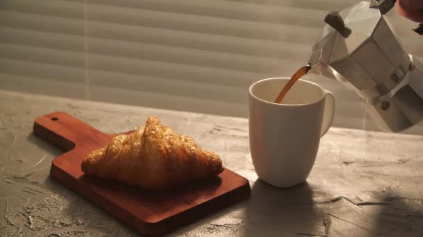 Étel és ital koncepció. Reggeli reggeli - kávé és croissant az asztalon — Stock videók