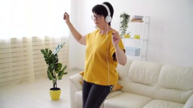 Güzel, son sınıf güzeli. Rahatlamış, dans ediyor, evde müzik dinliyor..