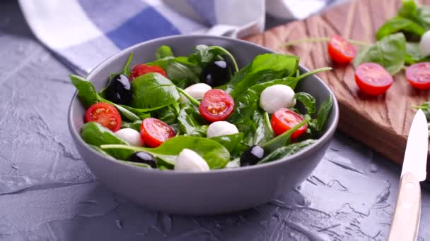 Vejetaryen ve organik gıda konsepti. Caprese İtalyan ya da Akdeniz salatası. Domates mozzarella fesleğen siyah zeytin ve zeytin yağı dönüşümlü bırakır — Stok video