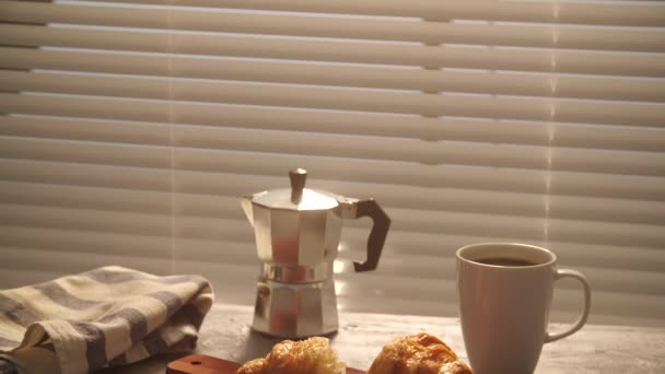 Eten en drinken concept. Ochtend ontbijt - koffie en croissant op tafel — Stockvideo