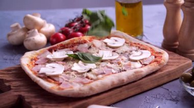 Fesleğen yaprakları pizzanın üstüne dökülüyor.