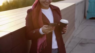 Genç Müslüman kadın tesettürlü, şehir dışında kahve molası veriyor.