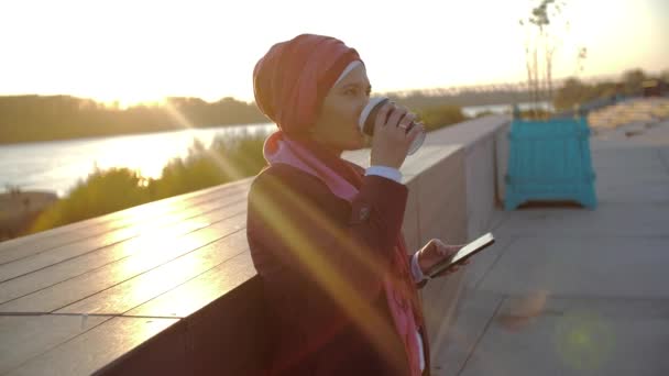 Jovem mulher muçulmana vestindo hijab tendo coffee break ao ar livre no fundo da cidade — Vídeo de Stock