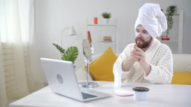 Deri tedavisi ve kişisel bakım konsepti. Gülümseyen genç adam evde göz maskesi takıyor.