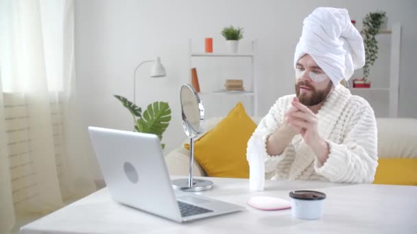 Traitement de la peau et concept d'autosoin. Jeune homme souriant appliquant un masque oculaire à la maison — Video