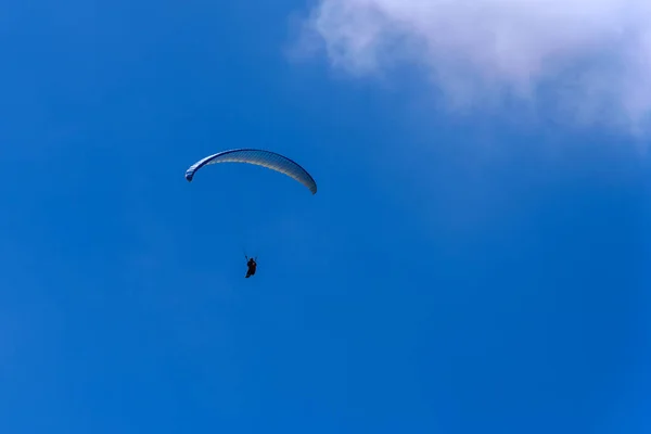 Летать на парашюте в голубом небе — стоковое фото