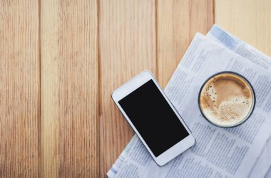 Gazete ve smartphone kafede kahve. 