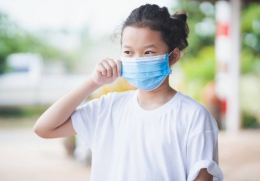 Koronavirüsü, covid-19 ve pm2.5 'u korumak için yüz maskesi takan Asyalı küçük kız.